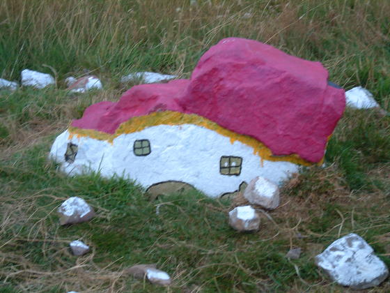 A large stone painted to look like a house